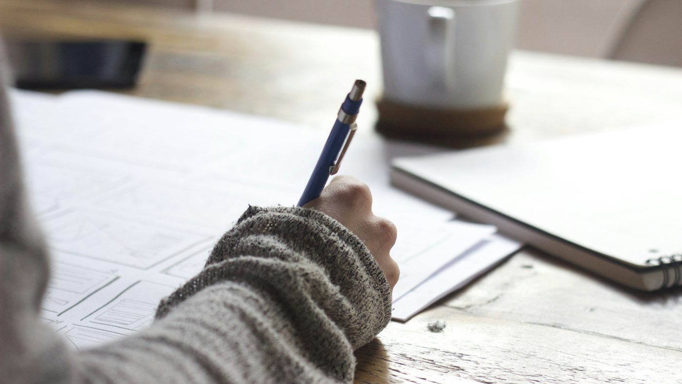 A simple written website brief on a desk in Dubai, with a phone and a page list