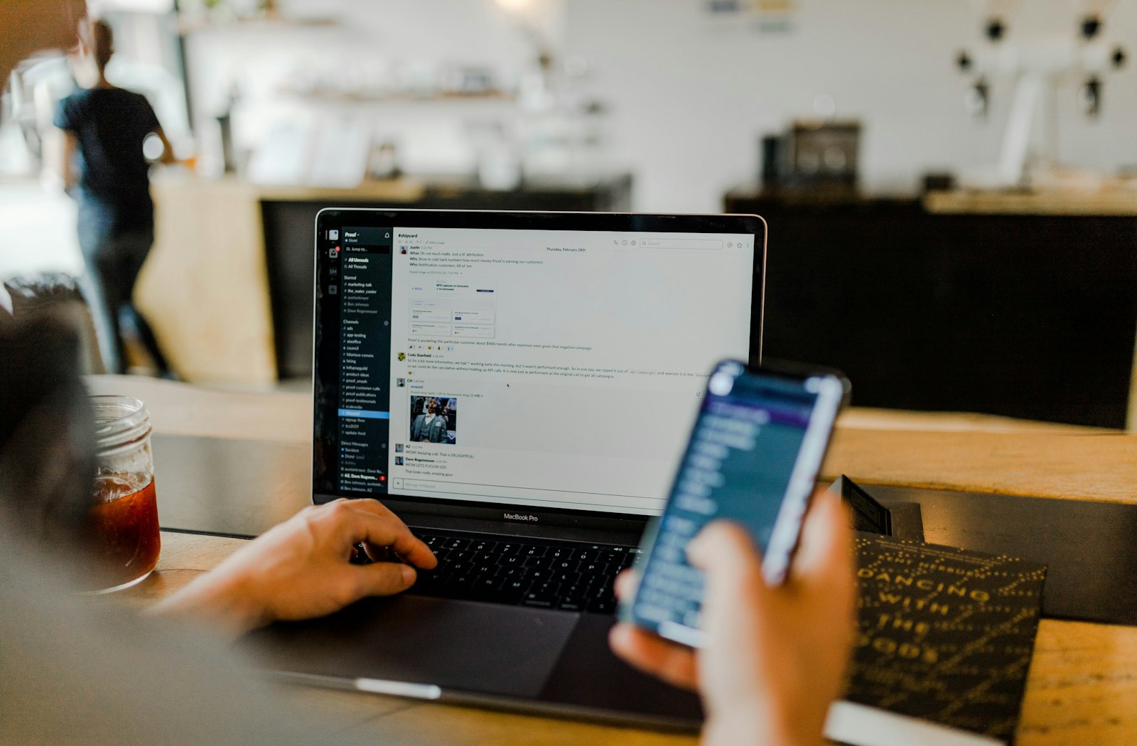 Person working on a laptop and phone in a cafe — business mail has to follow the domain